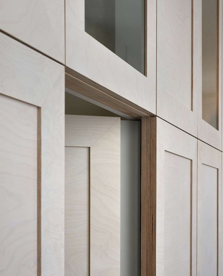 Detalle estructura de madera que encierra el cuarto de baño, con marcos que simulan frentes de armarios.