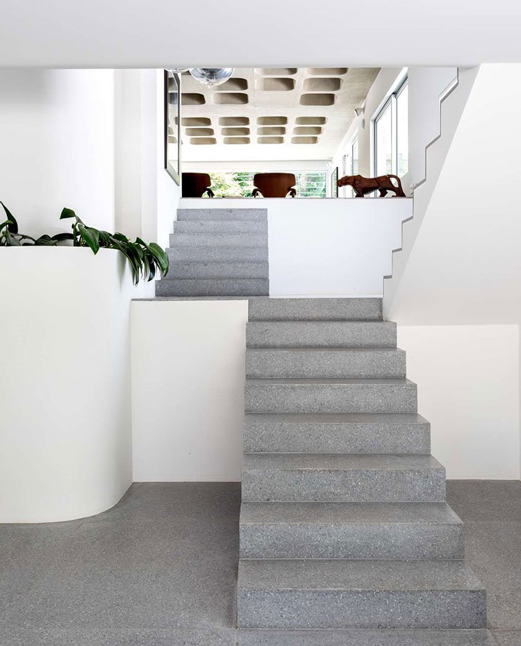 Escaleras-en-granito-gris-en-el-interior-de-la-vivienda,-en-diferentes-niveles,-paredes-en-blanco,-techos-con-orificios