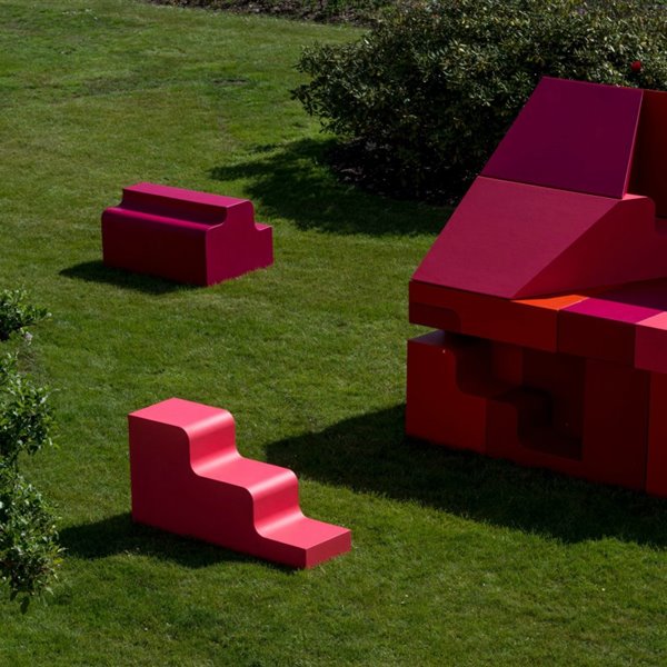 Los bloques de tonos rosas y rojos se combinan entre ellos para formar asientos, gradas o una vivienda.