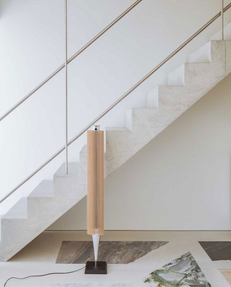 Escaleras de mármol, pasamanos tubular de acero, altavoz de pie color crema