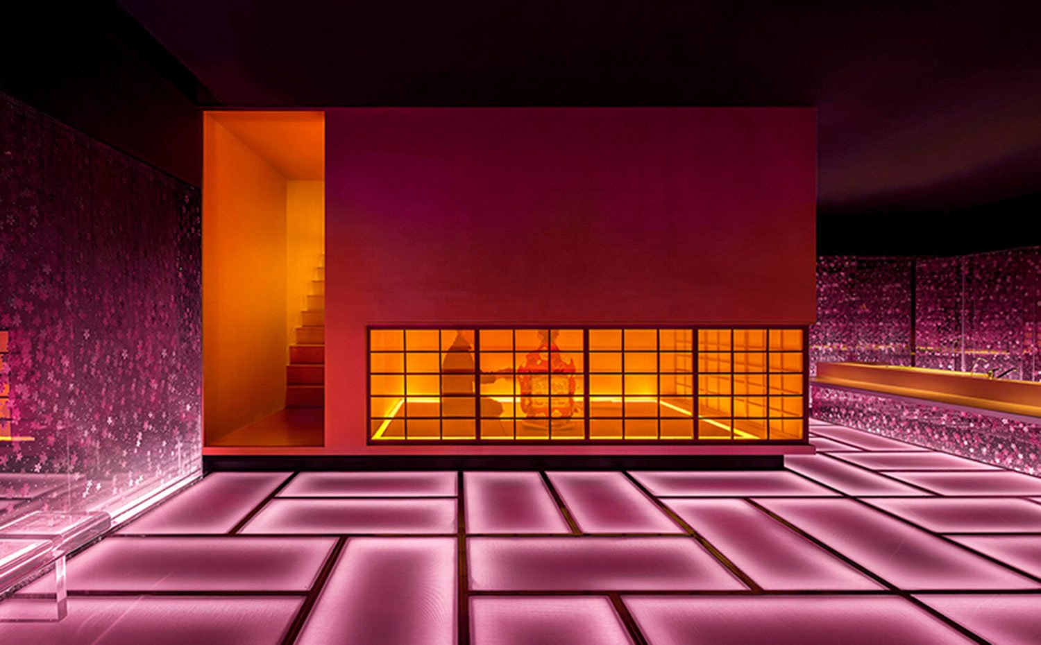 Vista general sala privada con escaleras acceso en tonos amarillos, suelo con fluorescencias en rosa