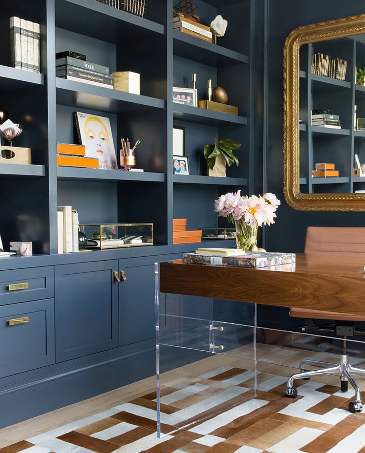 Zona de trabajo con mobiliario hecho a medida con acabado en azul, silla de piel y acero, mesa de madra y acrílico, espejo con marco dorado
