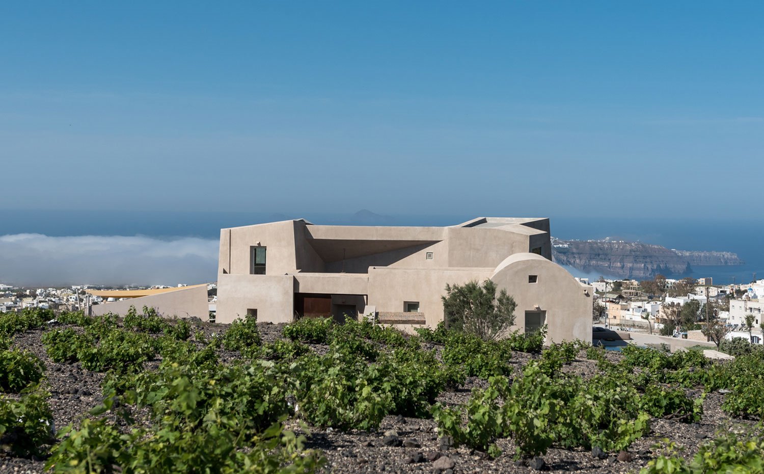 Fachada trasera de la casa, junto a viñedos y vistas a la costa