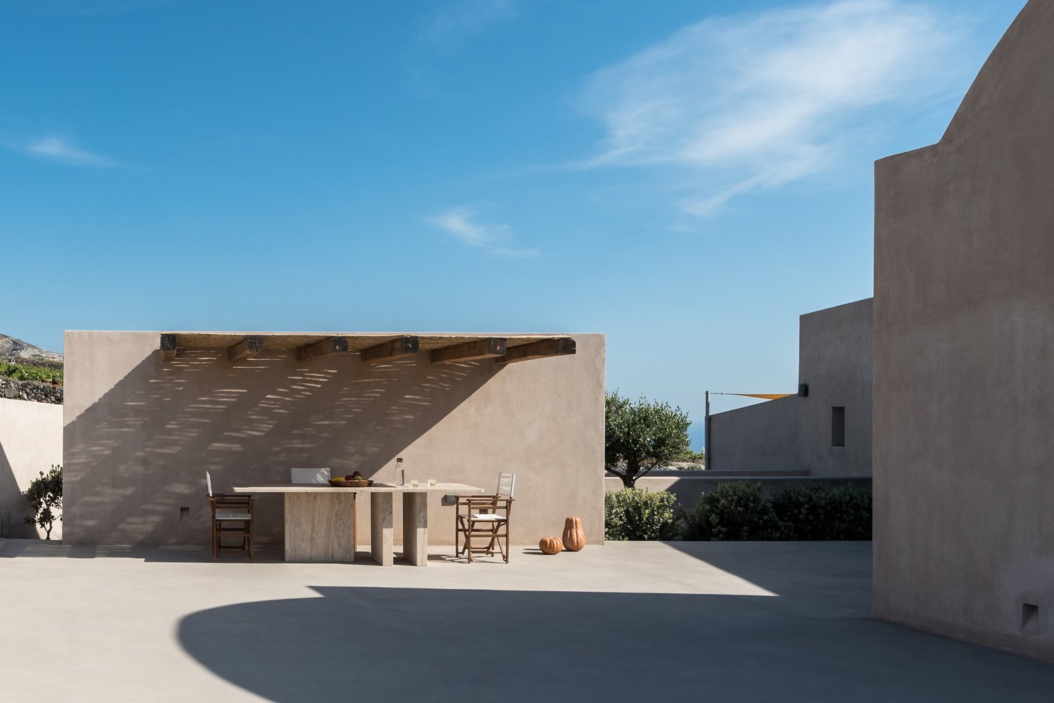 Comedor exterior con celosía en el techo, estructura de hormigón