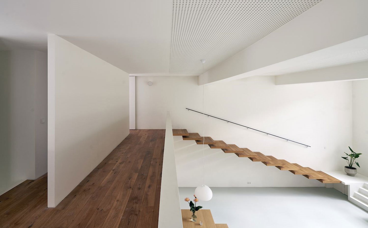 Planta superior con suelo de madera, muro divisorio, balcón de obra a salón u comedor, techo perforado, luminaria suspendida