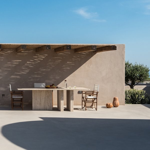 Comedor exterior con celosía en el techo, estructura de hormigón
