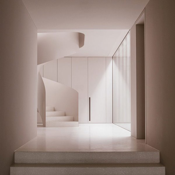 Escaleras de caracol hacia piso superior, frente de armarios en blanco, suelo blanco, cerramiento acristalado