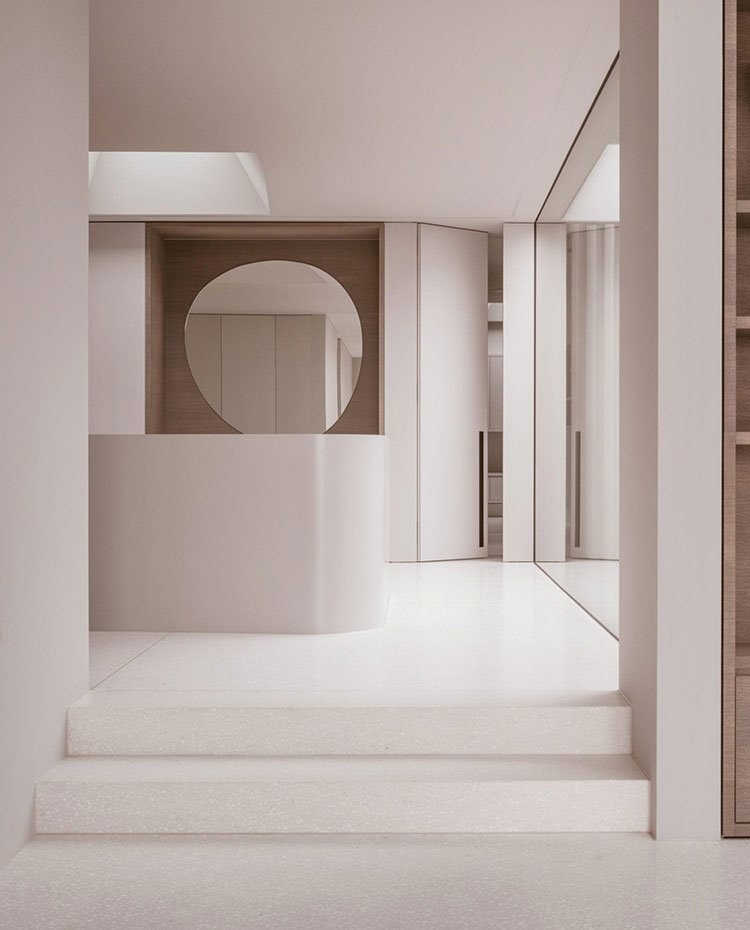 Interior vivienda, escaleras con elemento central organizador, cerramiento cristal y espejo circular