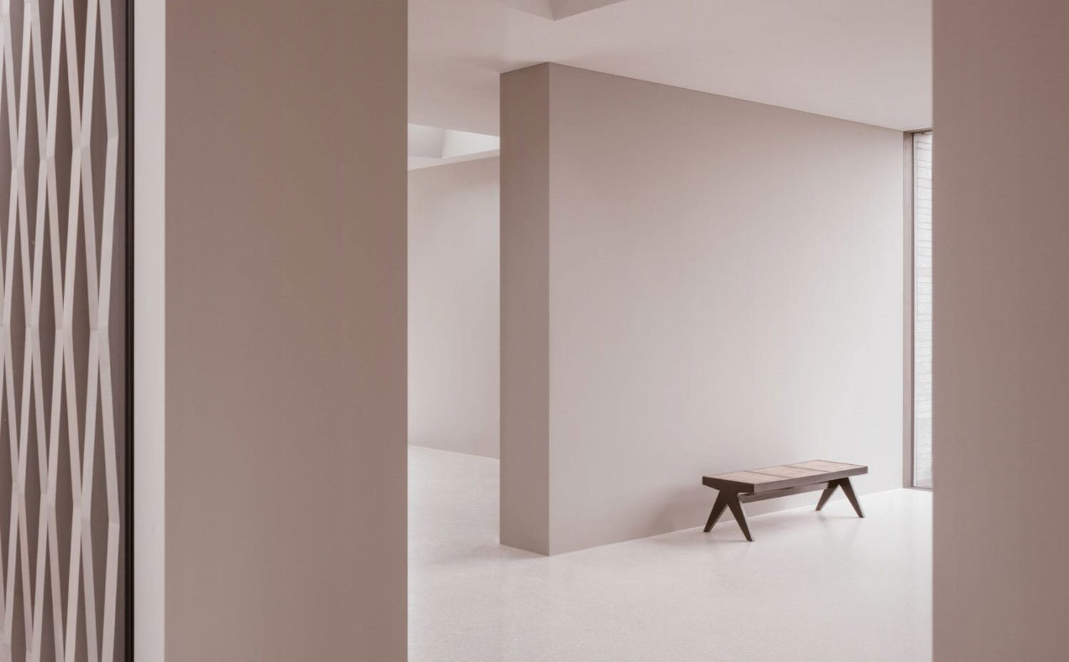 Zona pública con muros divisorios, banco de madera, detalle celosía en la pared