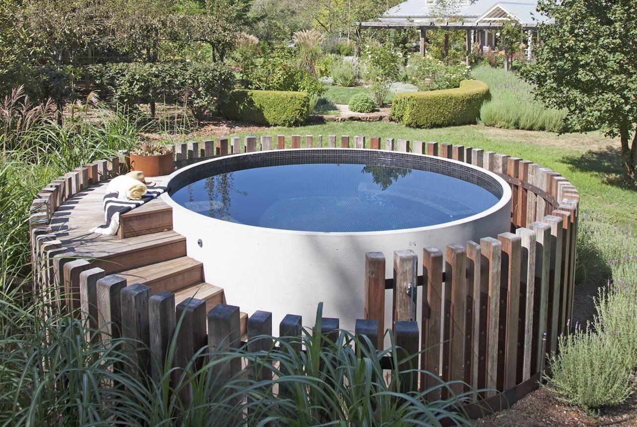 Piscina de hormigón con una valla de madera