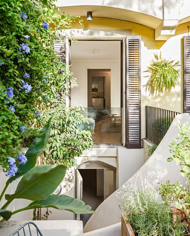 Exteror con vegetación junto a fachada vivienda, cerramientos con contraventanas