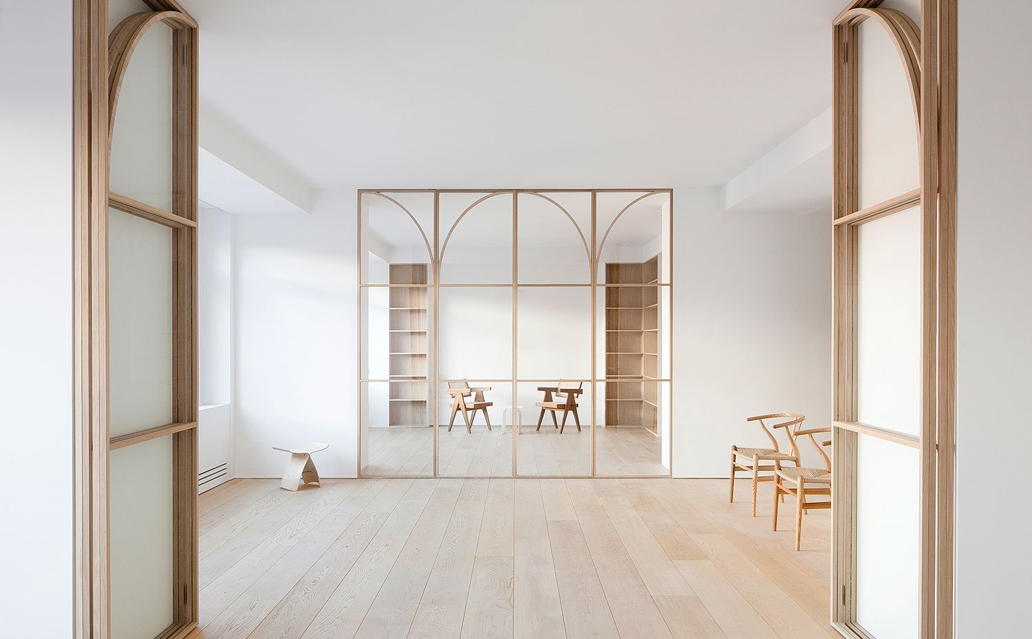 Cerramientos-plegables-en-cristal-y-perfilería-de-madera,-sillas-de-madera-y-estanterías-de-fondo
