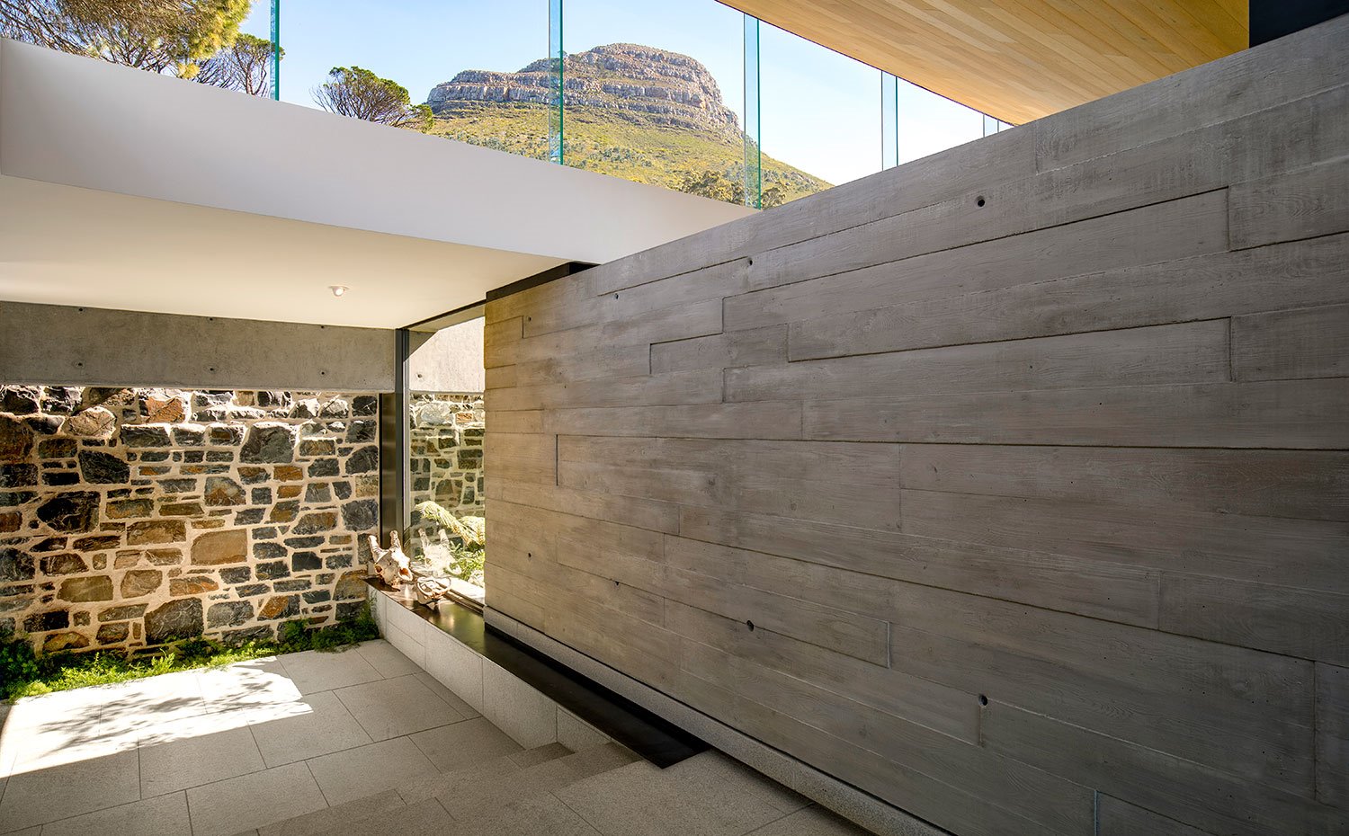 Paredes interiores revestidas de piedra y madera, cerramientos de cristal
