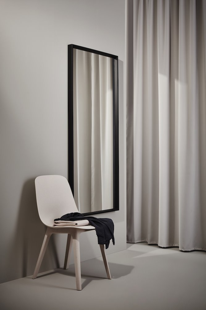 Silla de plastico recilcado de color rosa y espejo con marco negro de Ikea