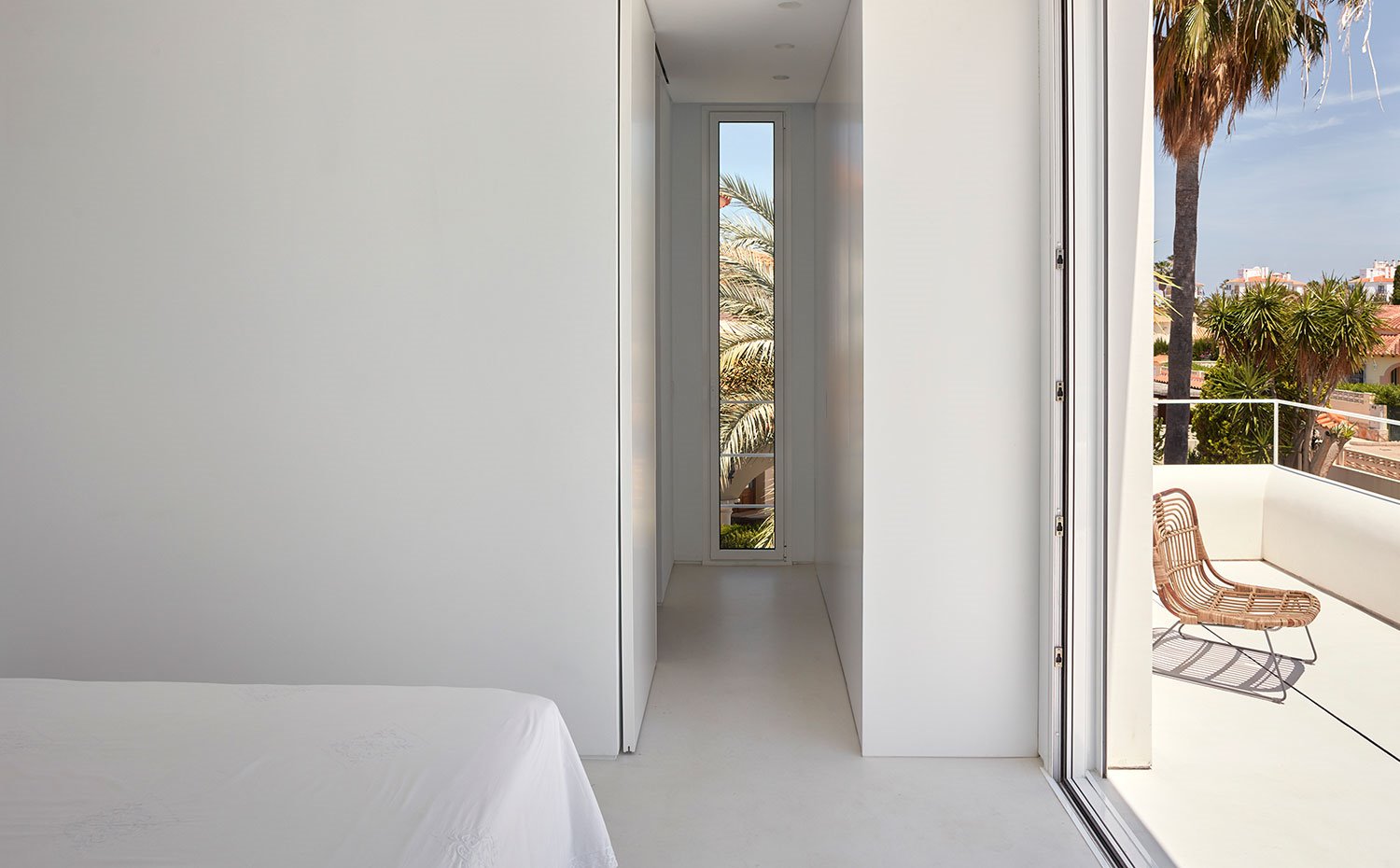 Dormitorio con puertas correderas, cerramientos de cristal y ventanas verticales