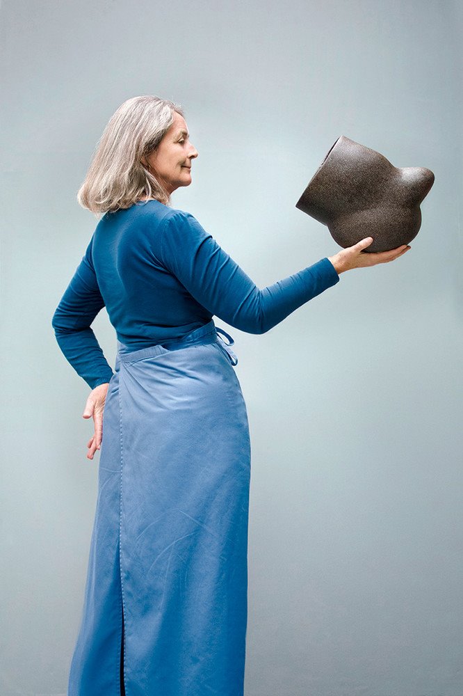 La ceramista Deirdre McLoughlin sostiene su obra, Waterwork I. 