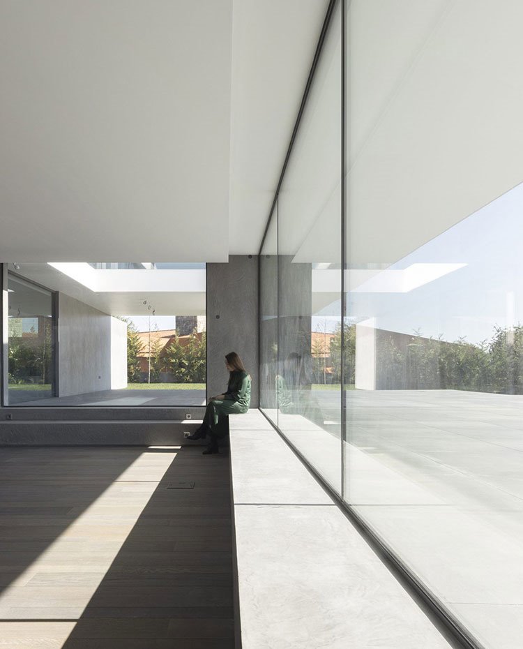 Interior sala diáfana con cerramiento de cristal y borde de obra a modo de asiento