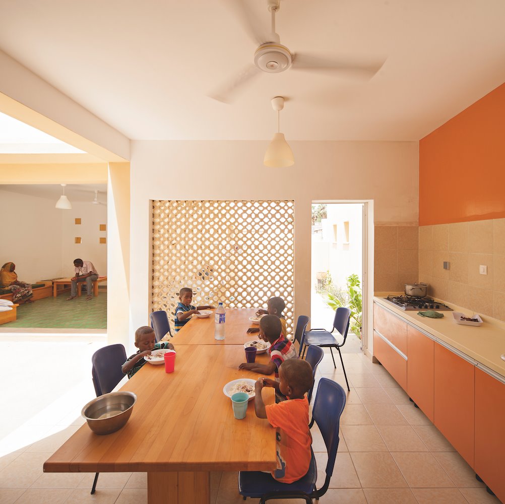 Comedor de un colegio en sudafrica diseñado por Urko Sanchez. En las casas se procuró ventilación natural y protección solar para paliar el clima extremo de la región