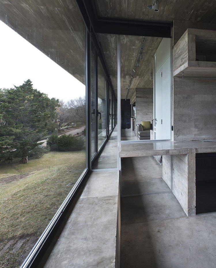 Detalle cocina con estructura de obra en hormigón, con vistas a zona boscosa