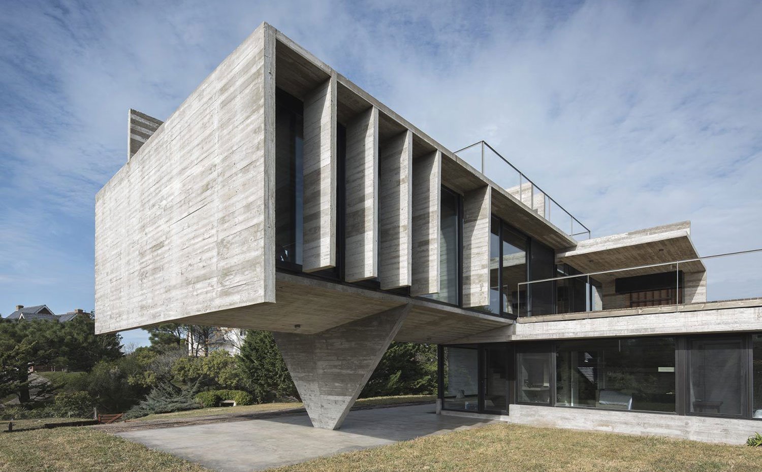 Exterior con vistas a los diferentes niveles de la casa hecha de hormigón y acristalamiento transparente