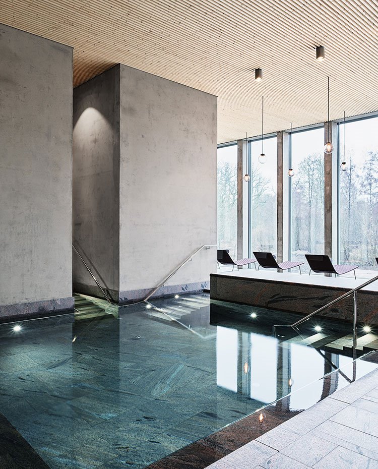 Piscina de granito, paredes de hormigón, techo de madera con focos y luminarias suspendidas