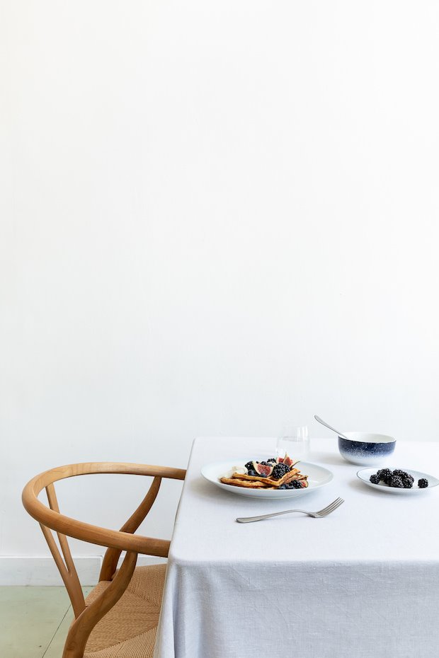 Mesa con manteleria blanca y platos de Wik & Walsoe