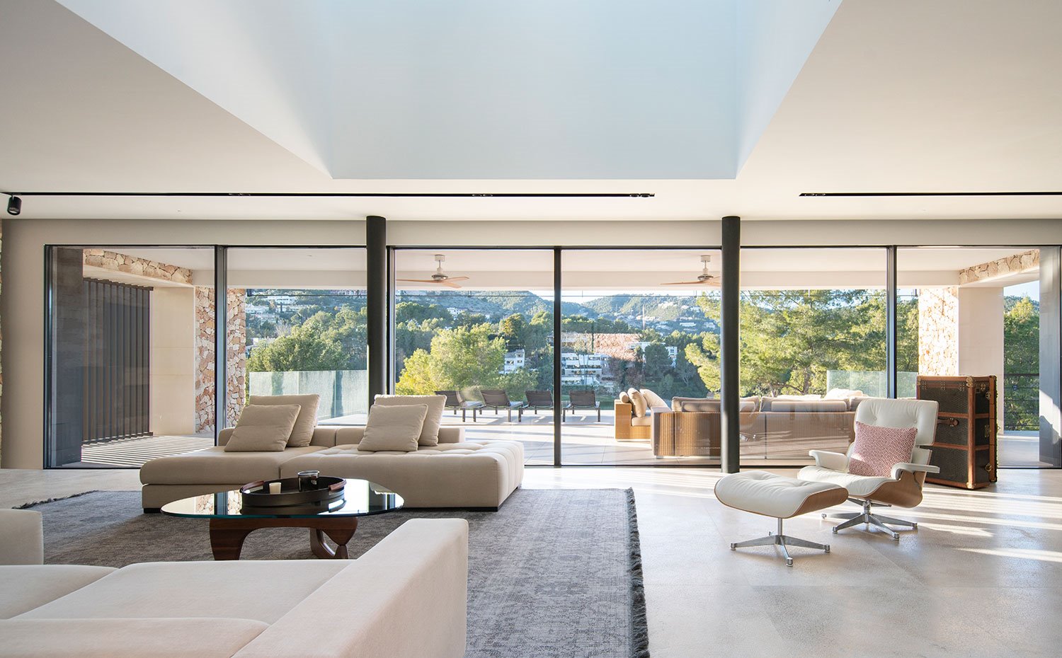 Gran lucernario en la zona central del salón y grandes cerramientos correderos de cristal transparente hacia la terraza exterior 