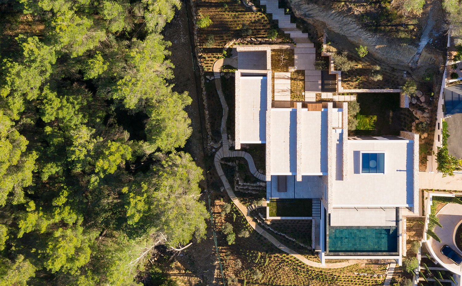 Vistaz cenital de la casa con los diferentes módulos separados con muros de piedra y gran piscina