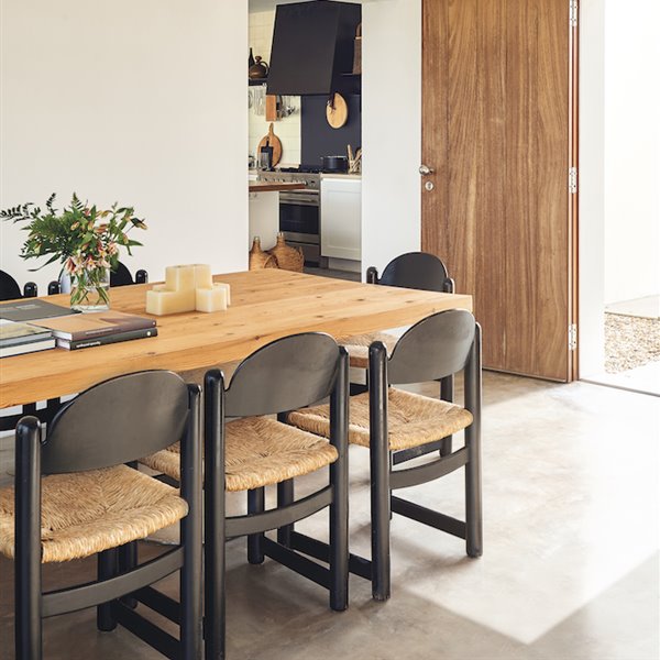 Comedor con pavimento continuo sillas de madera y mesa de madera