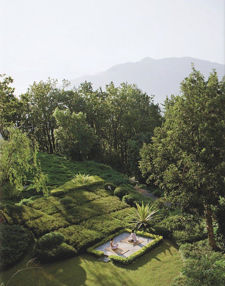 Jardin exterior con dos personas practicando yoga