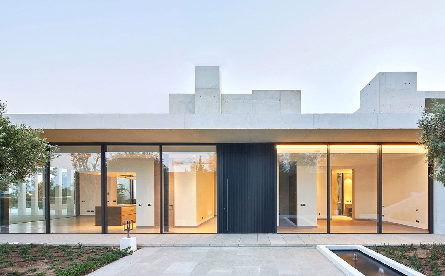 Puerta de acceso en planta superior con puerta de acero y cerramientos de cristal con vistas a interior de cocina y habitaciones