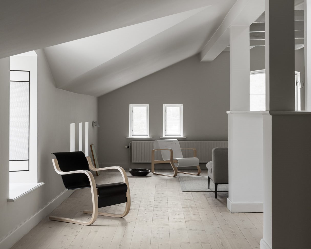 Casa establo de Frama Studio con sillas de Alvar Aalto y techos inclinados