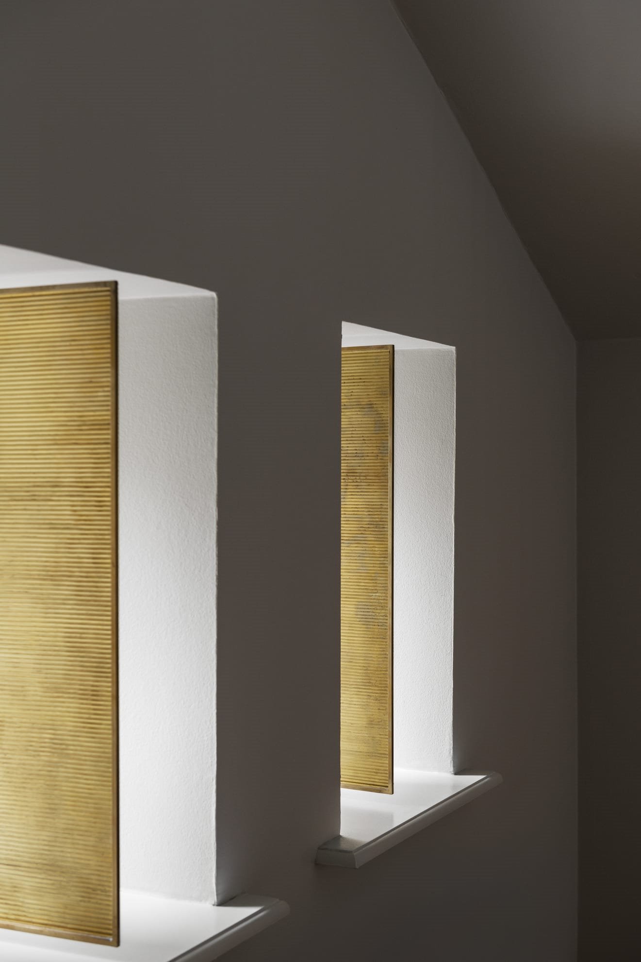 Detalle de las ventanas doradas de una casa reformada por Frame Studio