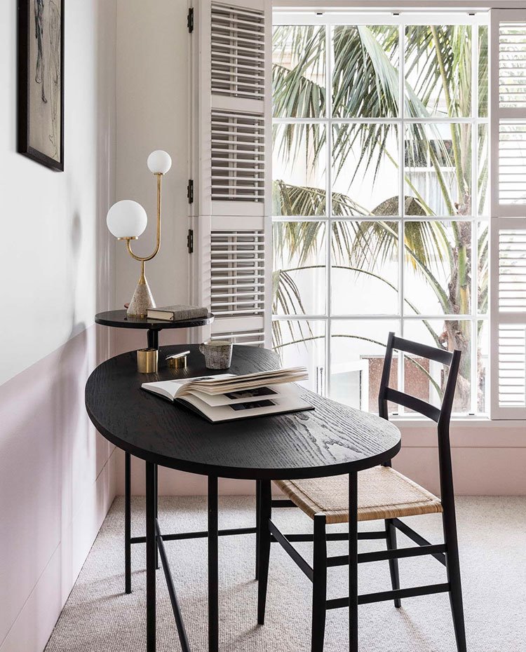 Mueble de trabajo en rincón de habitación todo de madera de oscura y silla a juego con asiento en madera clara