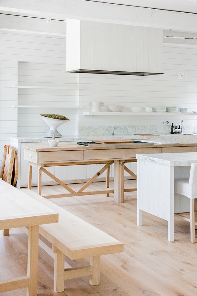 Cocina blanca con mesa de madera y banco