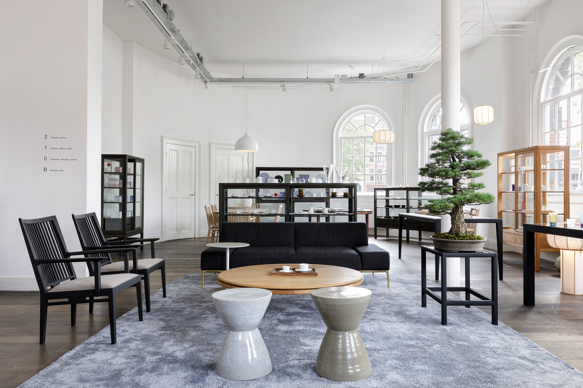 Tienda en Amsterdam de mobiliario moderno Time & Style creada por Kengo Kuma bonsai sillas negras y mesillas auxiliares lacadas