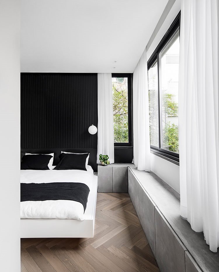 Dormitorio principal con cabecero en negro y somier en blanco en voladizo