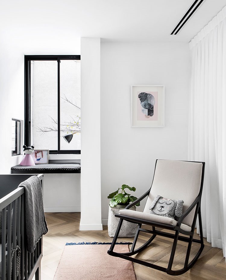 Habitación infantil con mecedora y cuna, cambiador junto a ventana