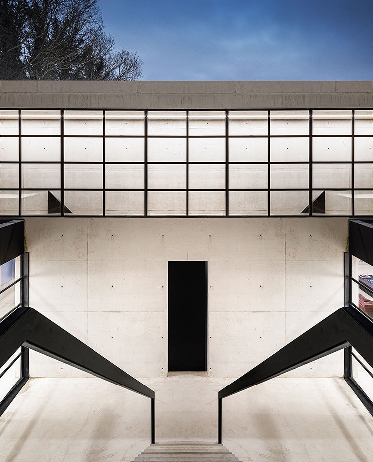 Patio exterior con escaleras que conducen al nivel superior a través de escaleras y cerramientos de cristal
