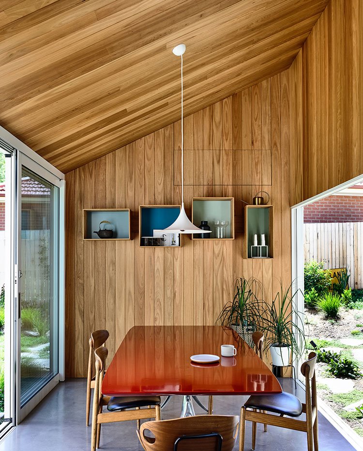 Comedor-revestido-de-madera-con-aperturas-laterales-a-exterior