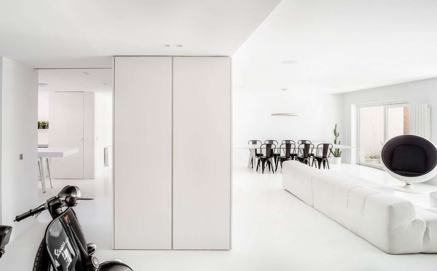 Armario-en-mueble-divisor-salón-cocina,-vespa-negra,-ball-chair-en-salón,-apertura-junto-a-comedor
