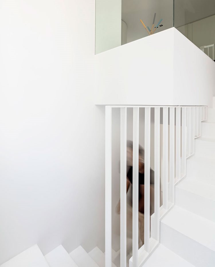 Escaleras de acceso al nivel superior en blanco con barandilla de cristal