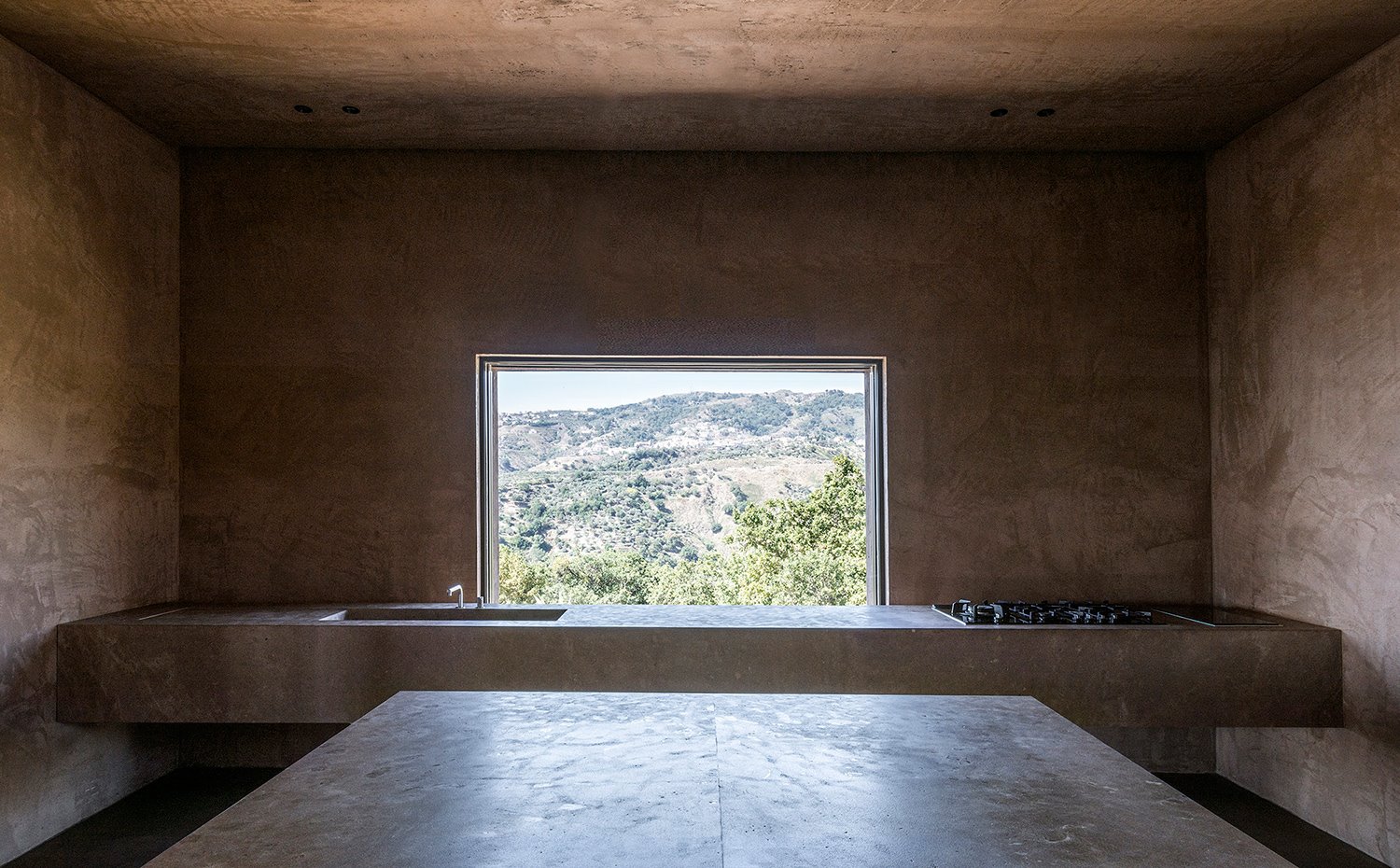 Interior cocina con mobiliario de obra y gran apertura al exterior