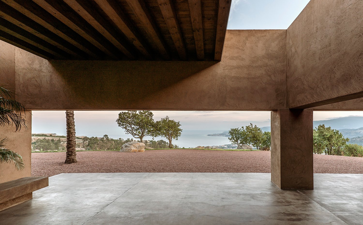 Porche exterior semicubierto con suelo de hormigón y vistas al mar