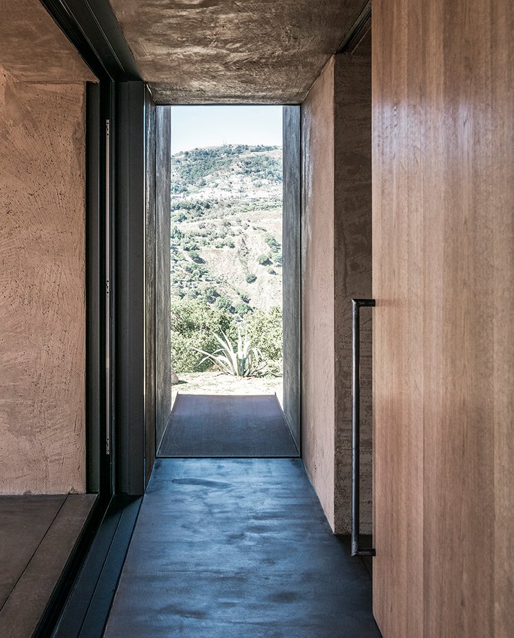 Zona de paso entre interior vivienda y exterior con carpintería de aluminio y puertas correderas de madera