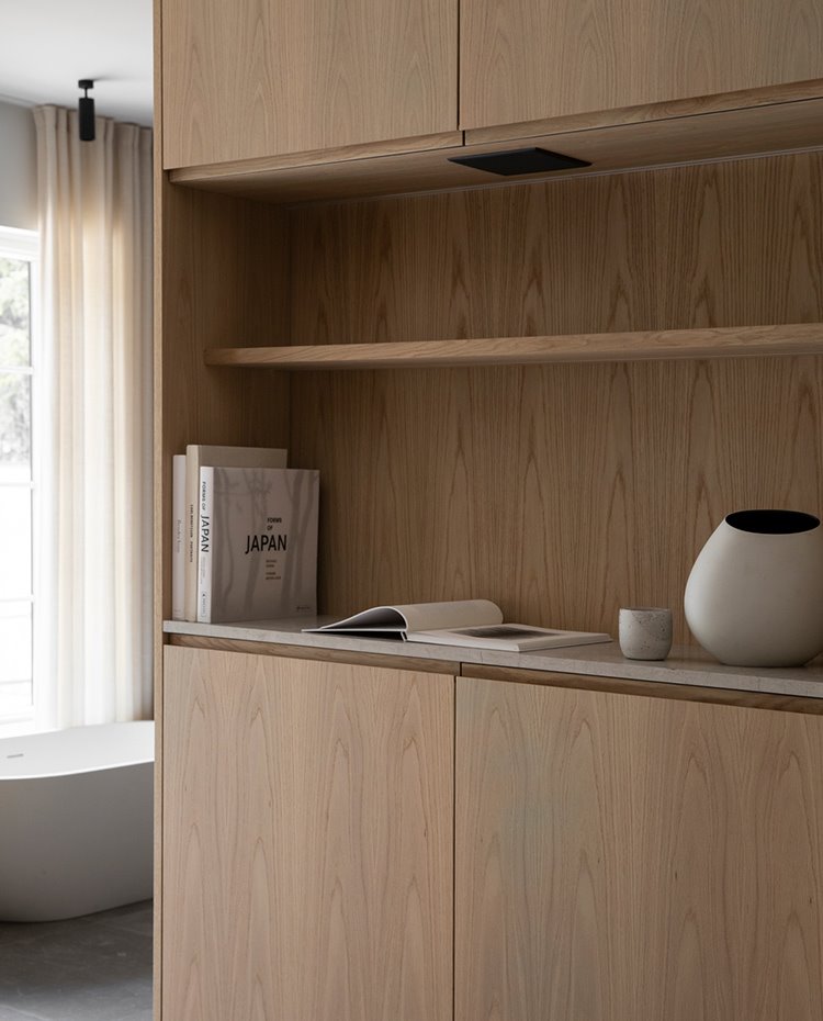 Mueble almacenaje con estantería en dormitorio junto a bañera