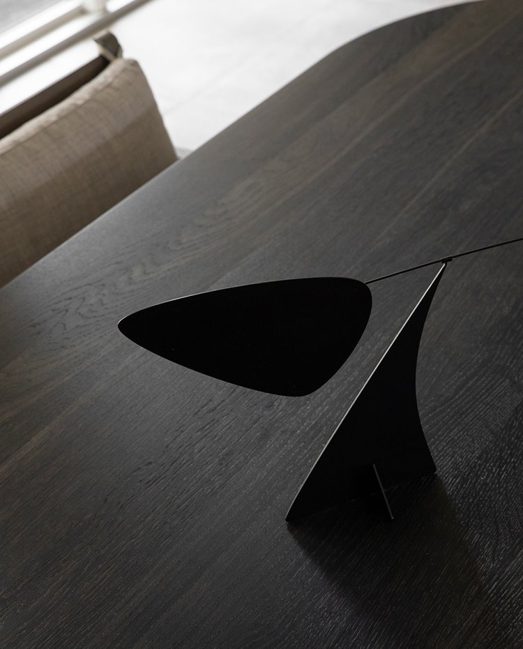 Pieza negra escultórica sobre mesa de madera