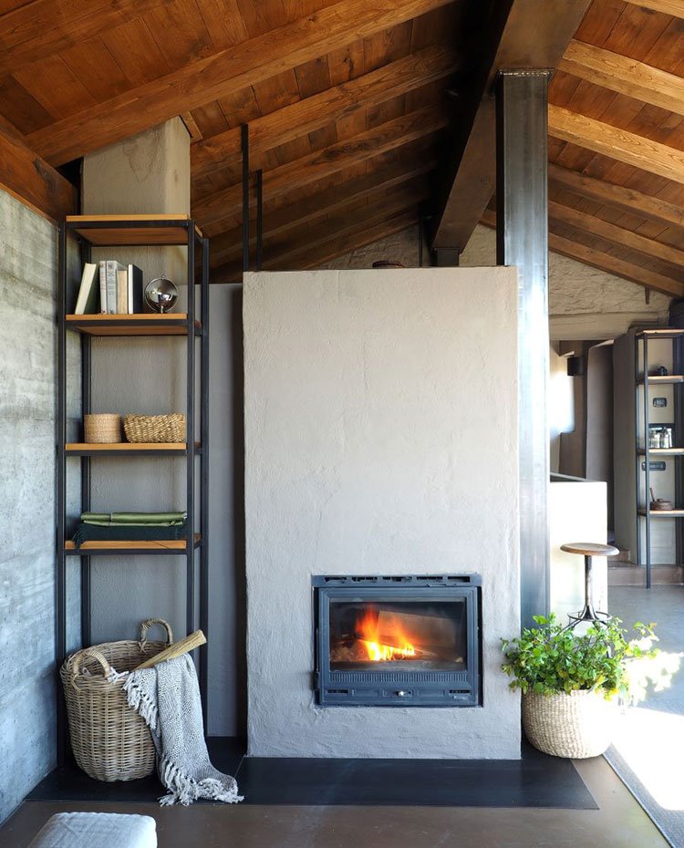 Chimenea en salón con estantería esquinera en hierro y madera, cesto de mimbre