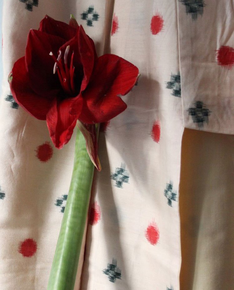 Detalle flor roja sobre estampado de prenda de ropa