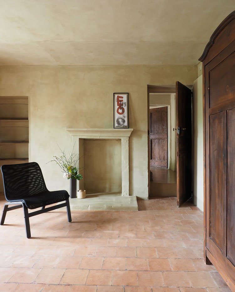 Salón con paredes de cemento, suelo de gres, armarios y puertasd de madera
